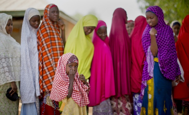 A young Nigerian girl from the Hausa tribe stands next to the line as her mother joins others queuing to validate their voting cards, at a polling station located in an Islamic school in Daura, the home town of opposition candidate Gen. Muhammadu Buhari, in northern Nigeria Saturday, March 28, 2015. Nigerians went to the polls Saturday in presidential elections which analysts say will be the most tightly contested in the history of Africa's richest nation and its largest democracy. (AP Photo/Ben Curtis)